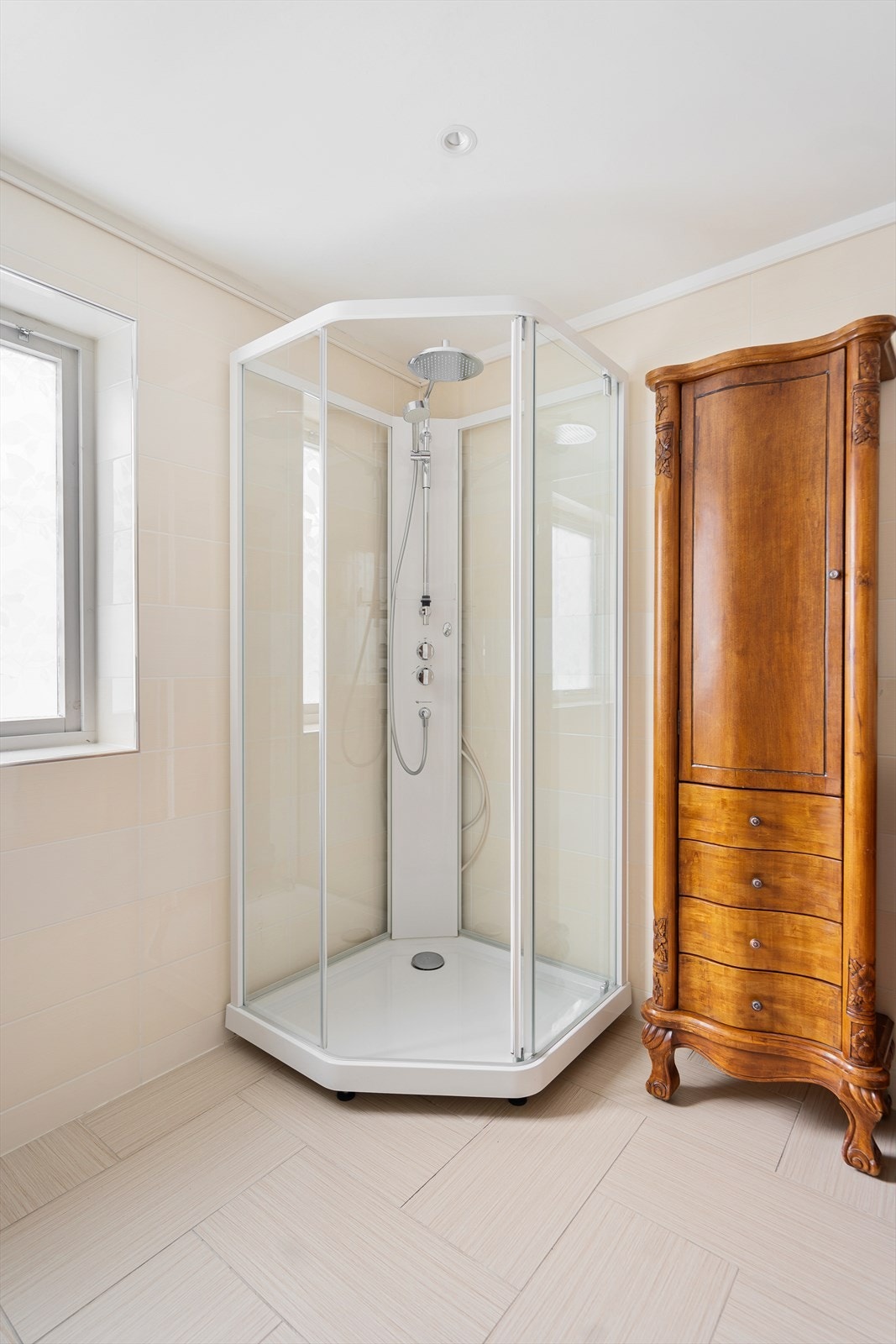 Lyst og delikat dusjhjørne med moderne armaturer og flislagte vegger - et innbydende sted å starte dagen Galleribilde