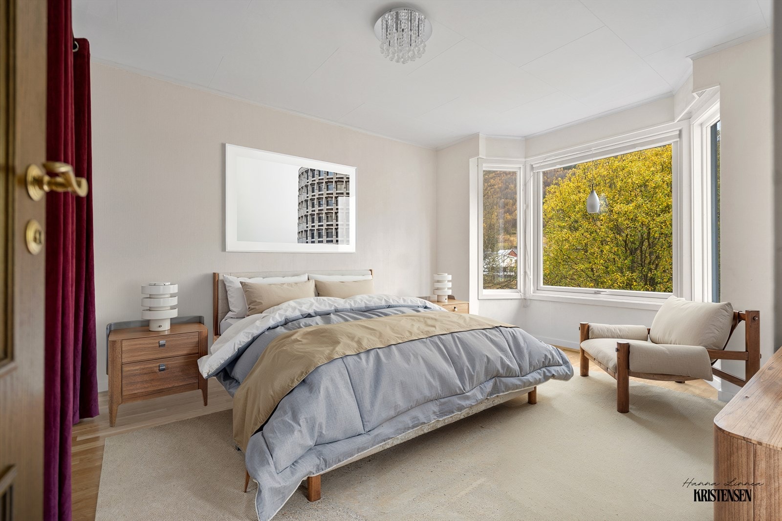 Soverom 1 - Soverommet har plass til stor seng, nattbord og lenestol, og de store vinduene gir en behagelig og naturlig atmosfære Galleribilde