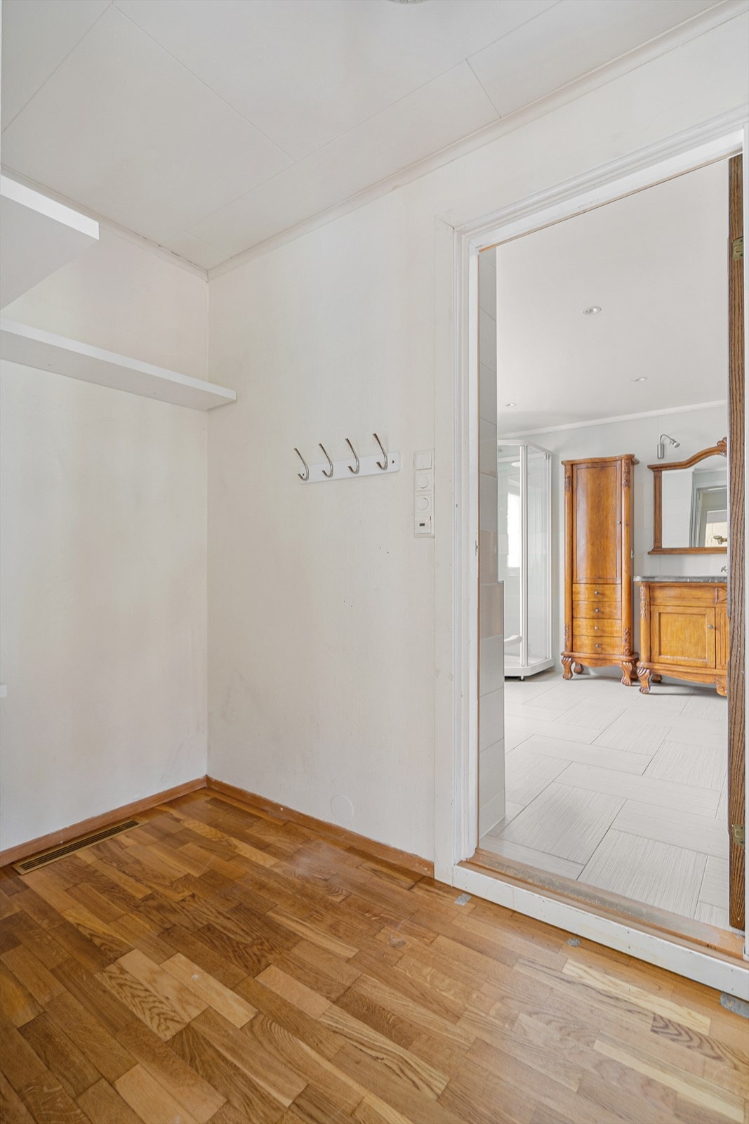 Lys og praktisk entré med plass til oppheng og oppbevaring. En naturlig velkomst inn i hjemmet Galleribilde