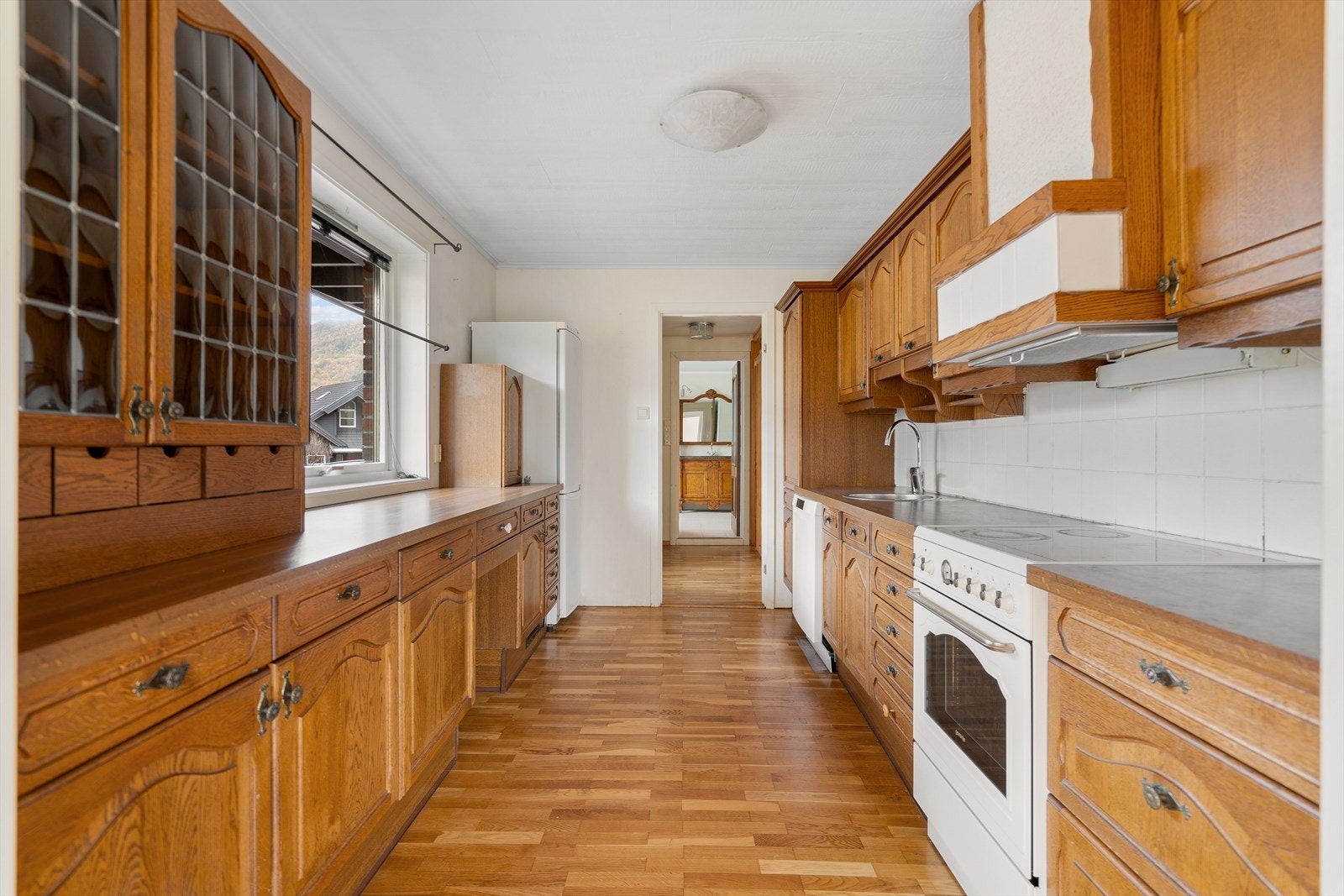 Kjøkkenet byr på god plass og solid innredning i heltre. Her er det rikelig med benkeplass og skapplass Galleribilde