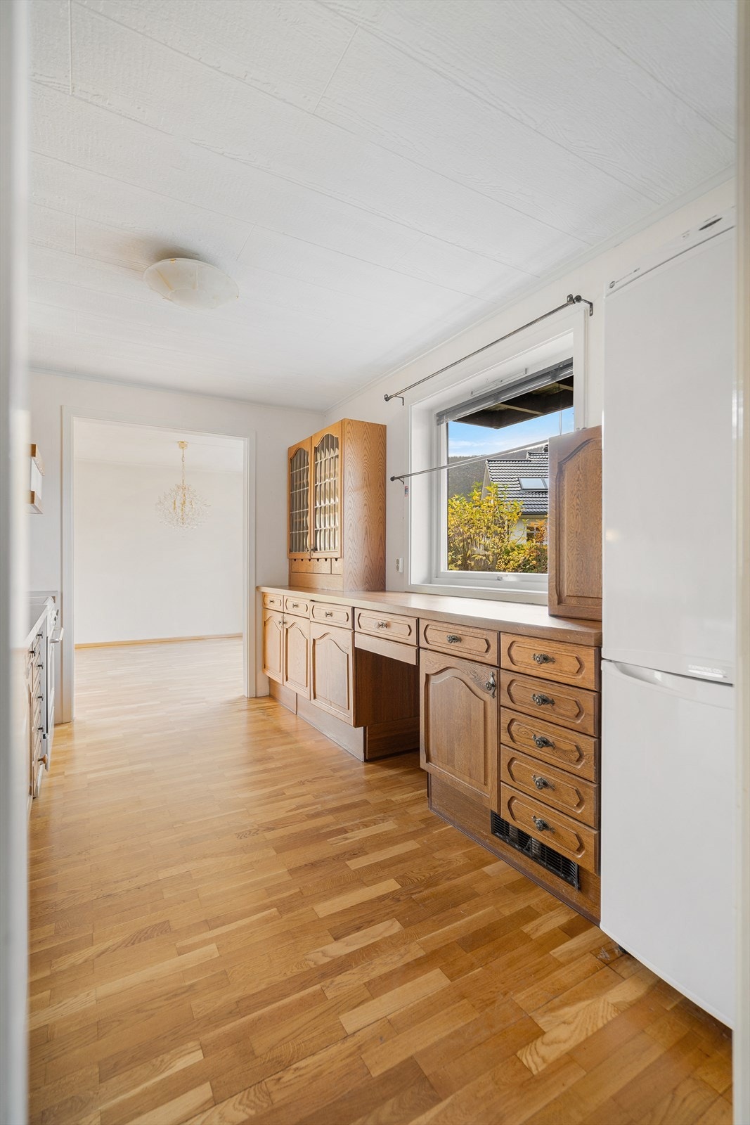 På kjøkkenet slipper lyset fint inn fra vinduet og gir kjøkkenet en lun og innbydende atmosfære - fra kjøkkenbenken har du utsyn mot hagen og nabolaget Galleribilde