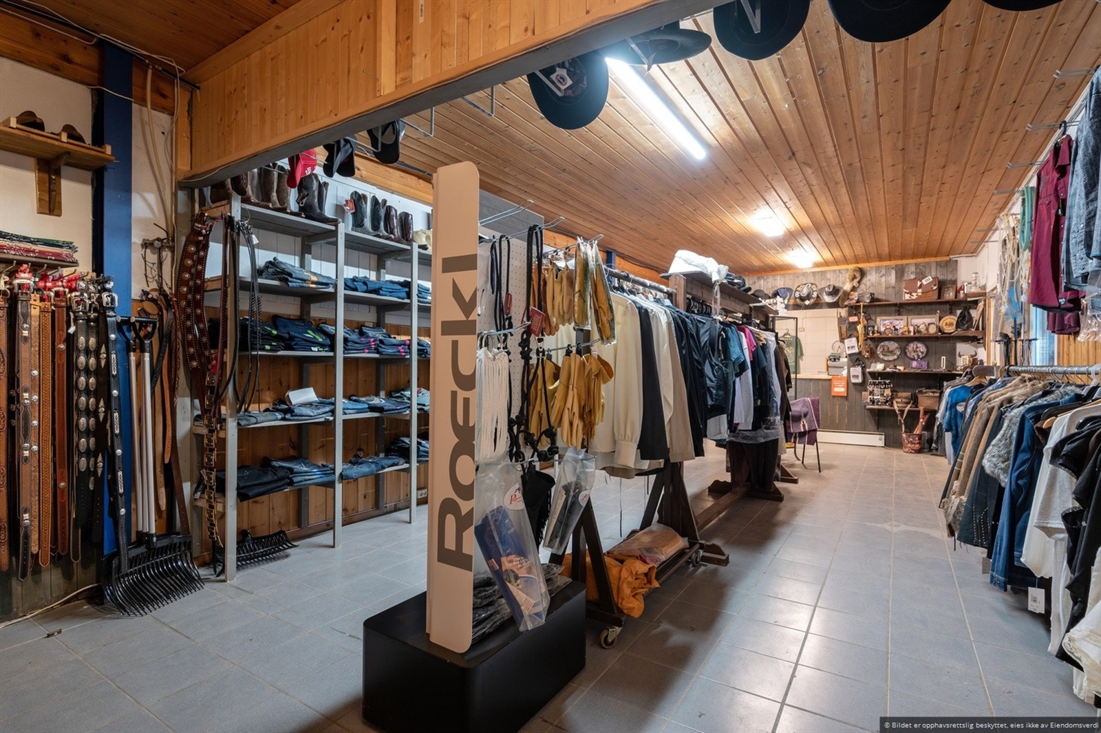 I bygningens vestgavl har det vært hesteutstyrsbutikk og wc/vaskerom i 1. etasje. Galleribilde