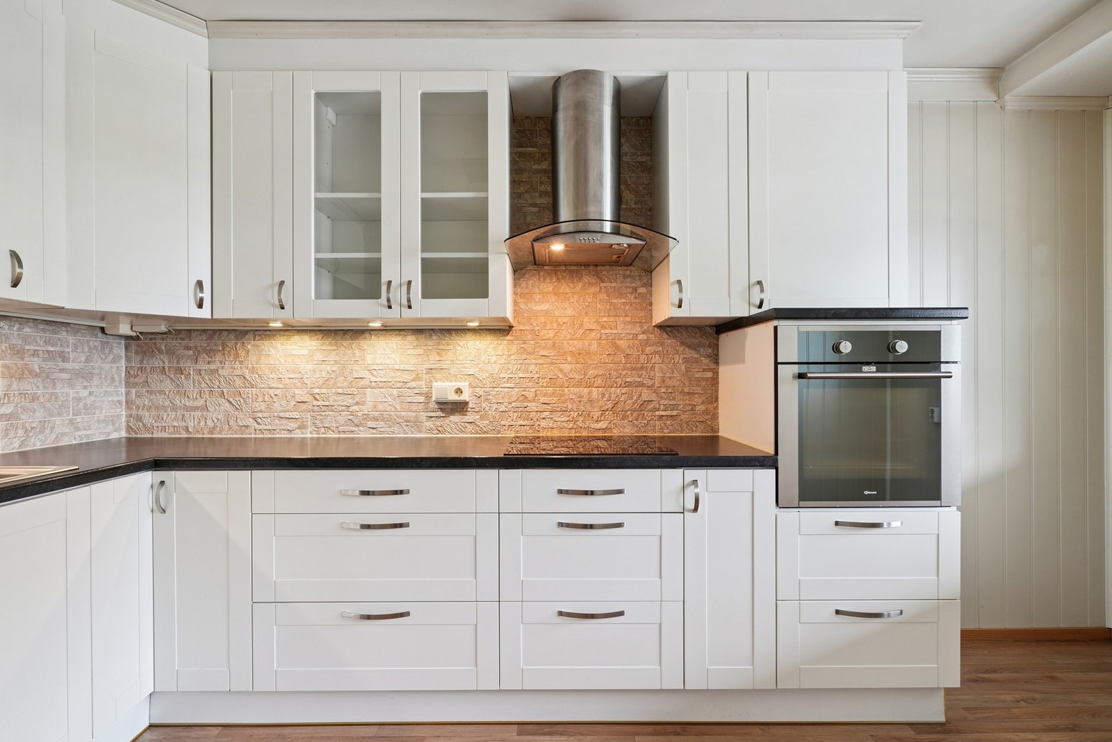 Det er lagt steinfliser på vegg over laminat benkeplate. Galleribilde