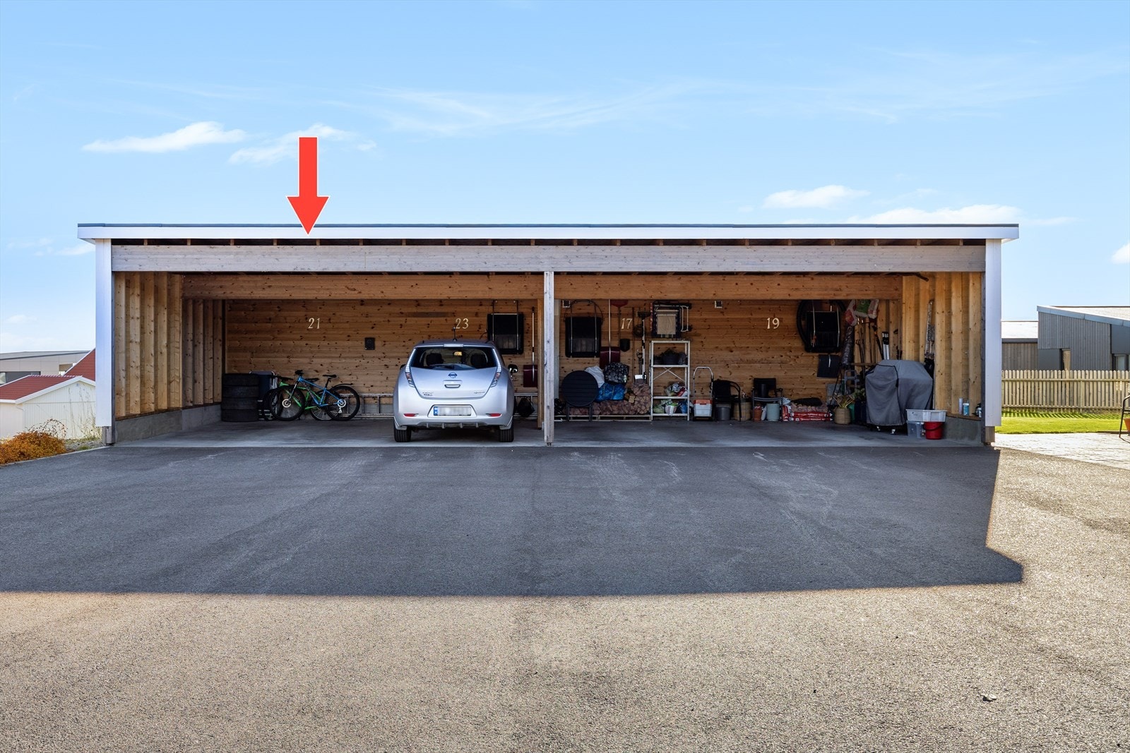 Parkering i carport med el-bil lader. Det er bod på baksiden av carporten Galleribilde
