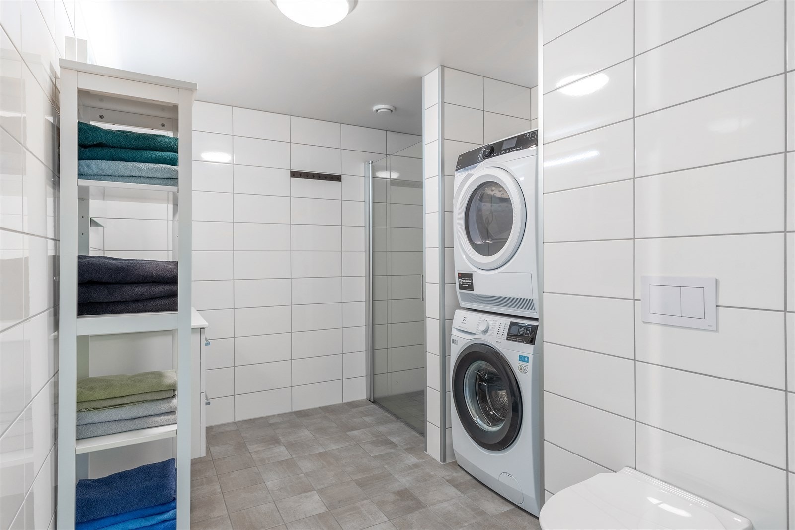 Badet er innredet med dusjhjørne, toalett og servant - samt opplegg for vaskemaskin Galleribilde