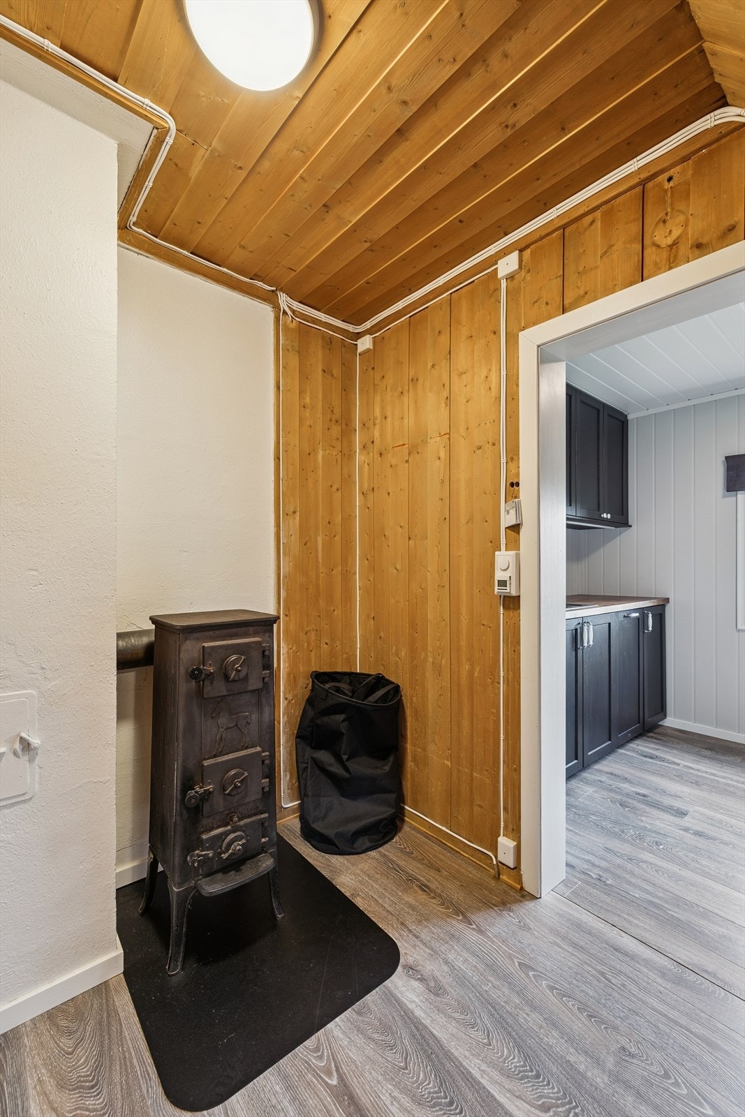 En eldre vedovn i gangen ved kjøkkenet. Galleribilde