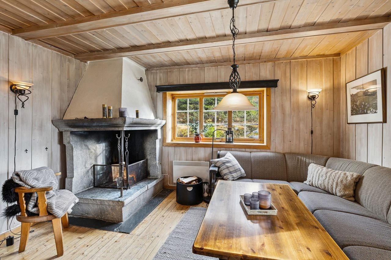 Den sentralt plasserte peisen i kleberstein skaper en lun atmosfære. Galleribilde