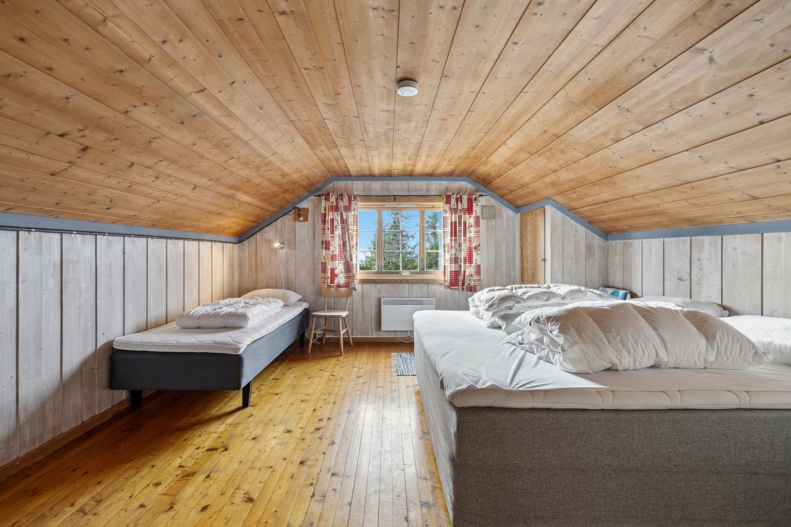 Det ene soverommet i andre etasje er romslig med plass til flere senger. Galleribilde