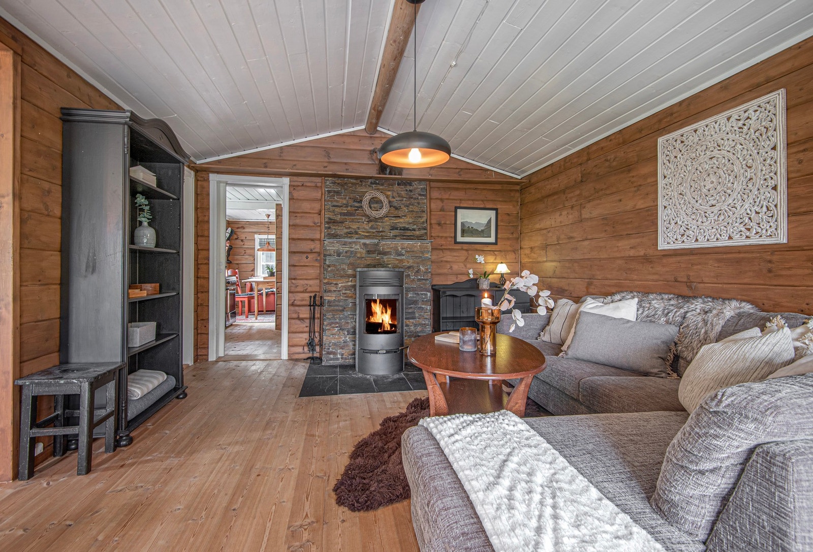 Den koselige stuen har god plass til hjørnesofa. Peisen er velfungerende og gir god varme. Galleribilde