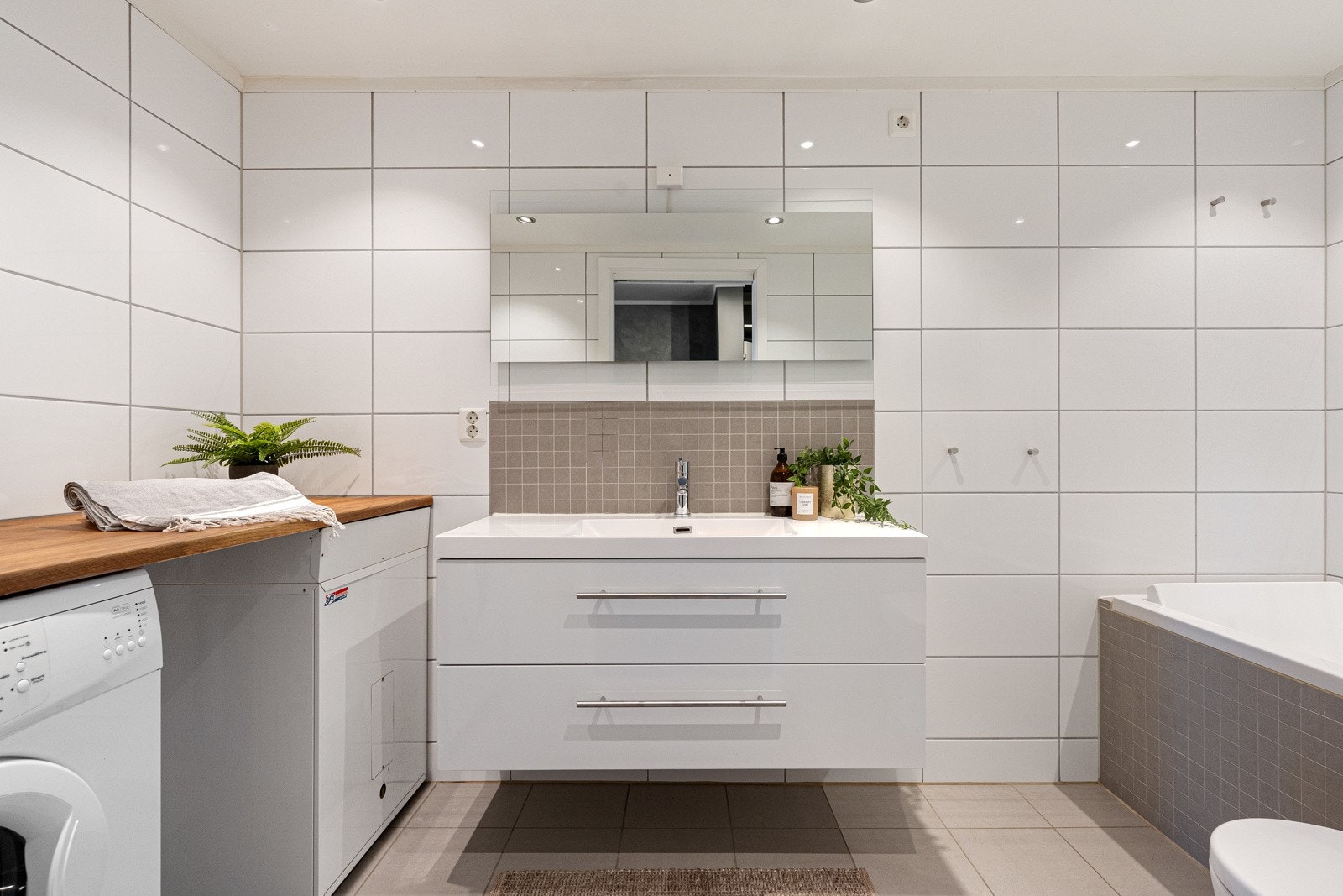 Praktisk og delikat bad med flislag gulv med varme og fliser på vegger Galleribilde