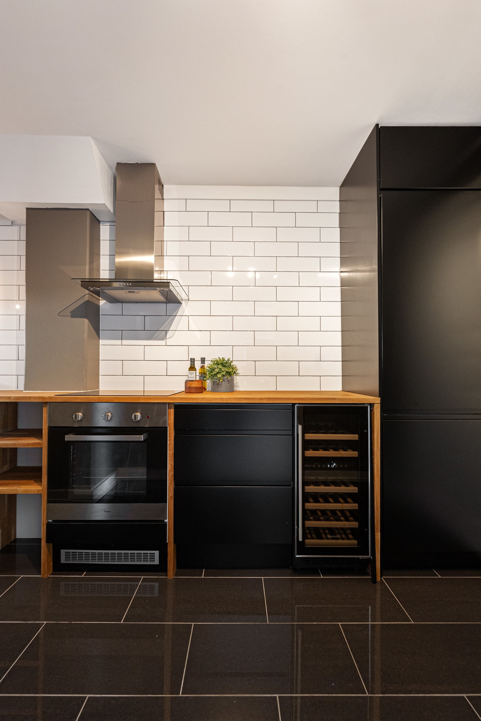 Kjøkkenet har integrerte hvitevarer; stekeovn, platetopp, oppvaskmaskin, vinskap og kjøleskap med fryser. Vegghengt ventilator. Galleribilde