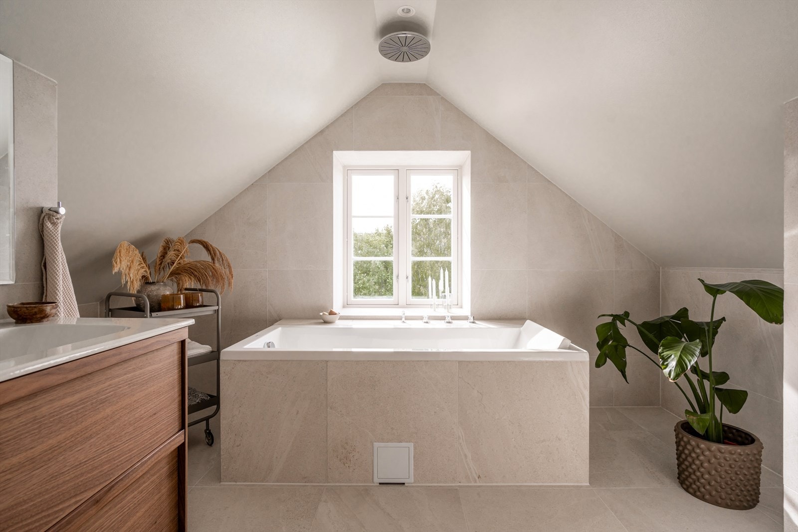 Inn på badet forsetter hotellfølelsen, med et behagelig badekar samt regnfallsdusj fra tak. Rehabilitert ifm. oppussingen i 2022/2023. Galleribilde