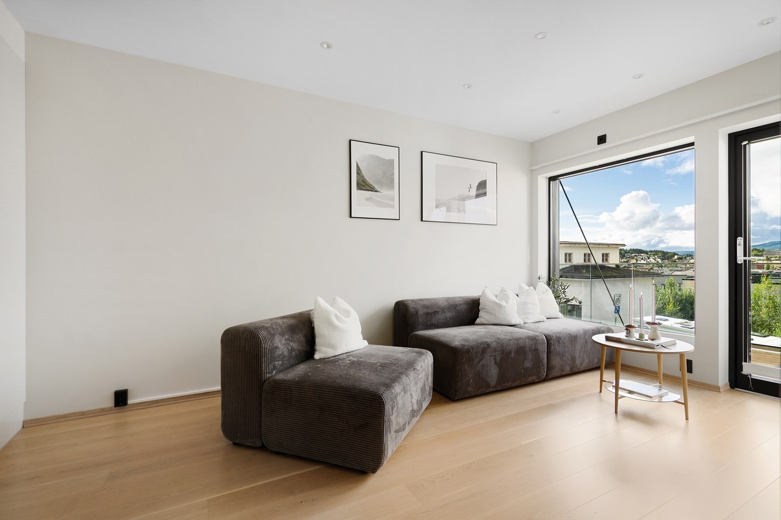 Stuen er åpen og lys med store vindu som slipper inn mye naturlig lys Galleribilde