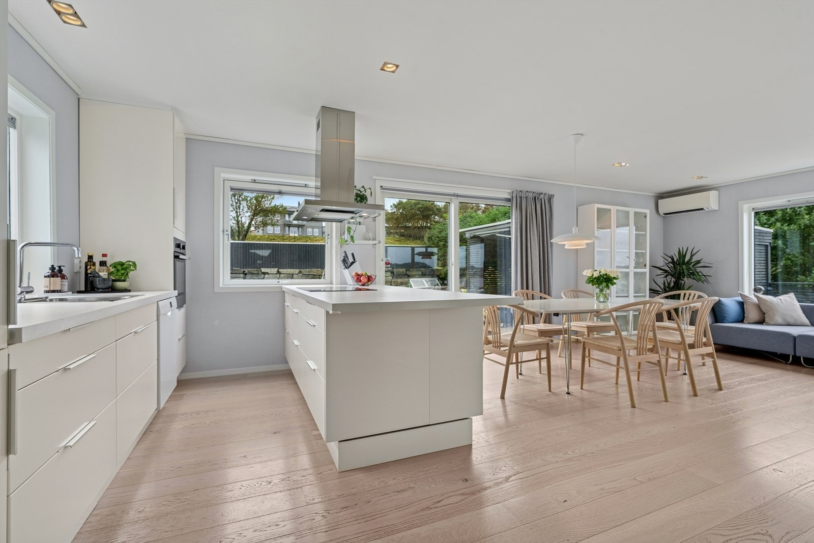 Tidløst hvitt kjøkken med glatte fronter og laminert benkeplate. Det er montert kjøkkenventilator over komfyr/platetopp. Godt utbygget med skap- og benkeplass. Galleribilde