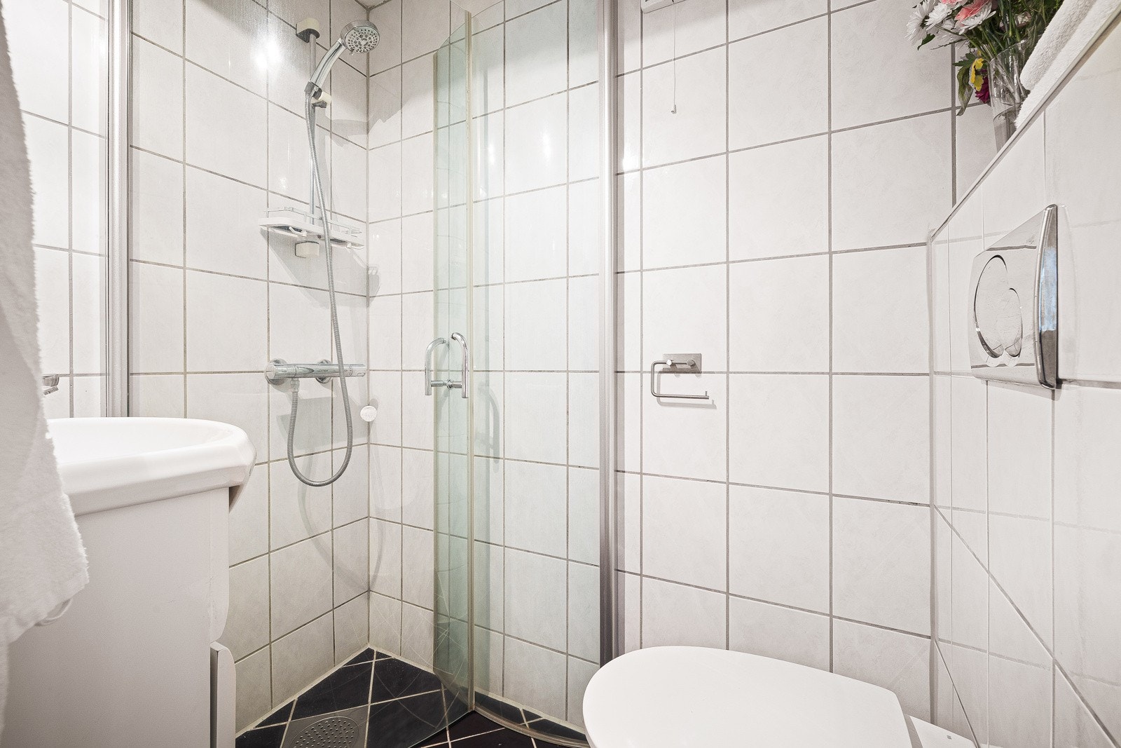 Badet er innredet med vegghengt toalett, dusjhjørne og baderomsinnredning med nedfelt servant. Galleribilde