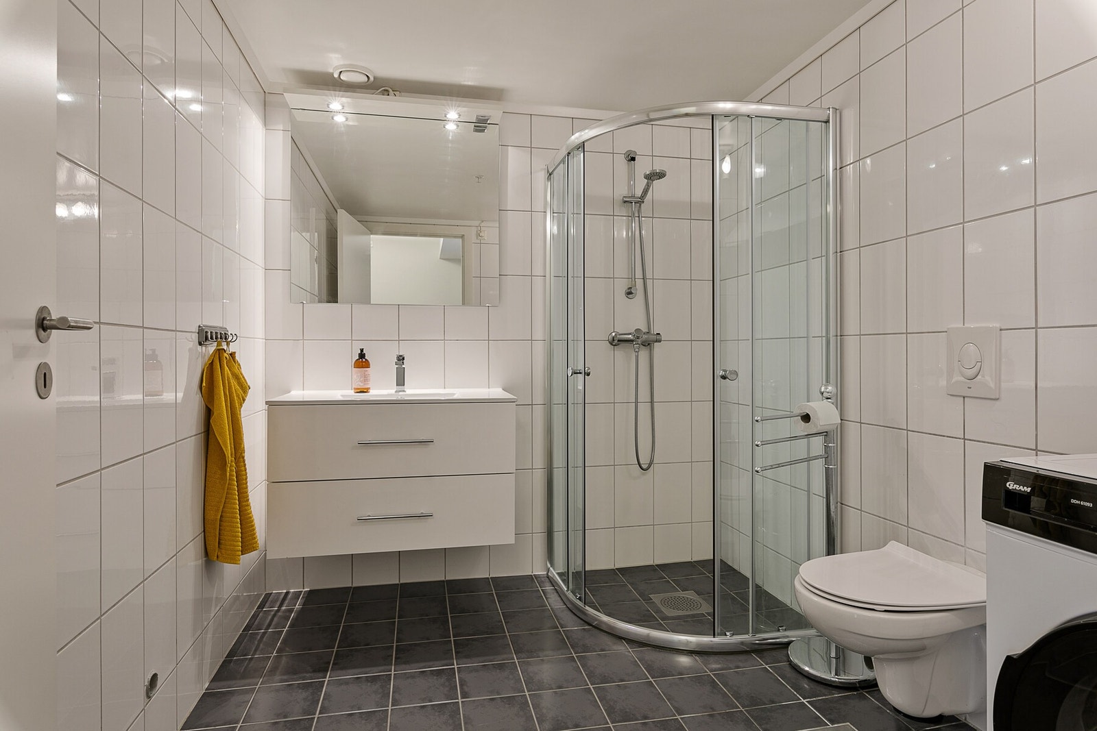 Romslig bad med plass til vaskemaskin hvor du har alt du trenger i leiligheten. Galleribilde