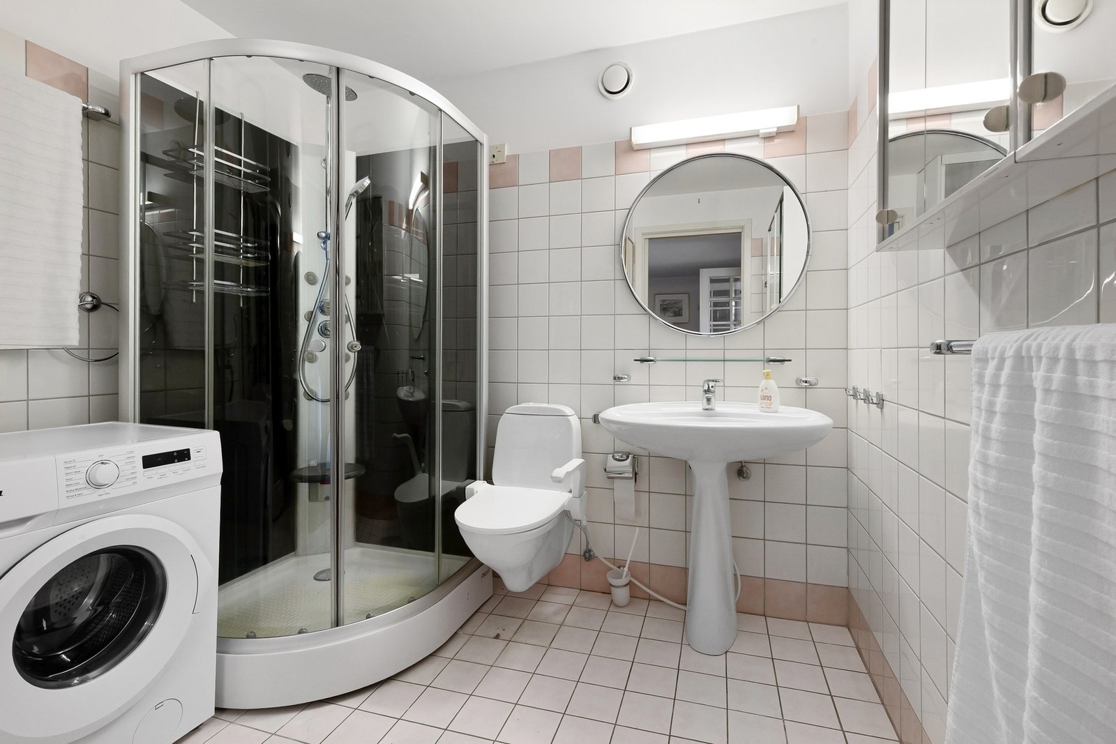 Badet er fullt utstyrt med servant, dusjkabinett og vegghengt klosett. Vaskemaskin. Galleribilde