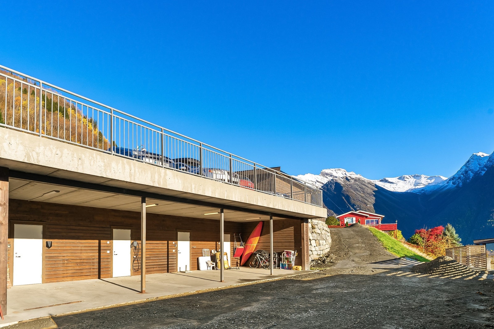 Parkering i carport med elbilladar. Gjesteparkering på taket. Sportsbod i bakkant av carporten. Galleribilde