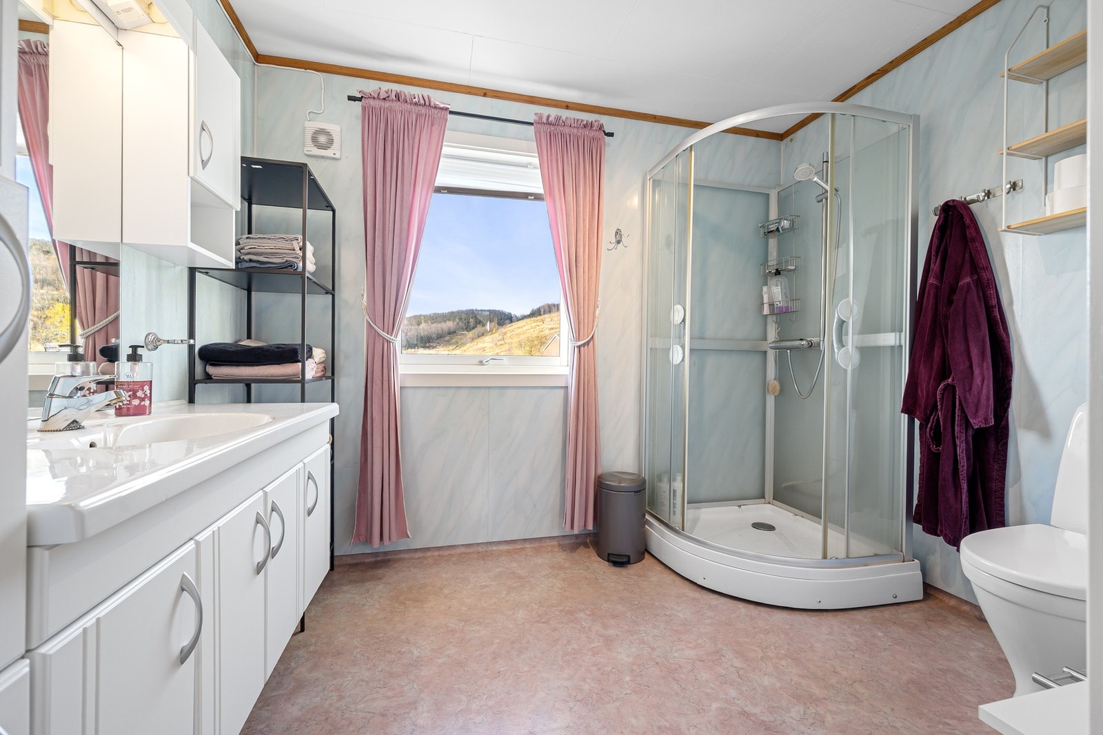 Badet inneholder servantinnredning, dusjkabinett og toalett Galleribilde