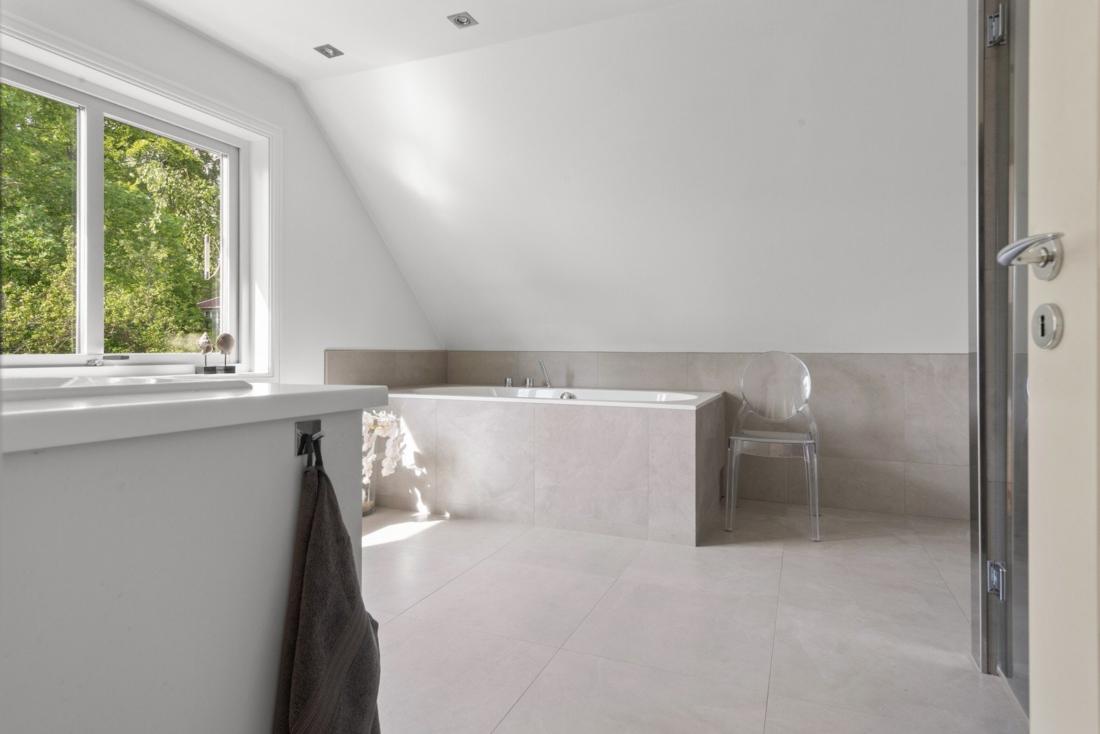 Påkostet dobbelbad tilknyttet hovedsoverom. Badekar kledd i tidløse store fliser, herlig med naturlig lysinnslipp Galleribilde