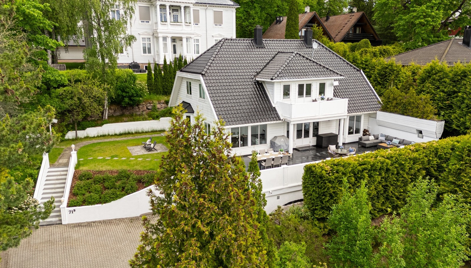 Svært flott villa over 3 plan av nyere dato i klassisk stil, med svart saltak og en elegant flislagt terrasse Galleribilde