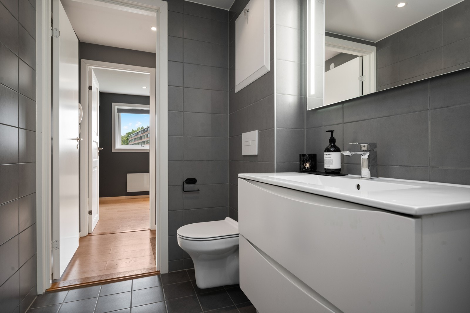 Baderommet ble pusset opp i regi av borettslaget i 2021, og er klassisk flislagt på gulv og vegger. Det er utstyrt med moderne innredning med heldekkende servant med speil over, i tillegg er det vegghengt wc Galleribilde