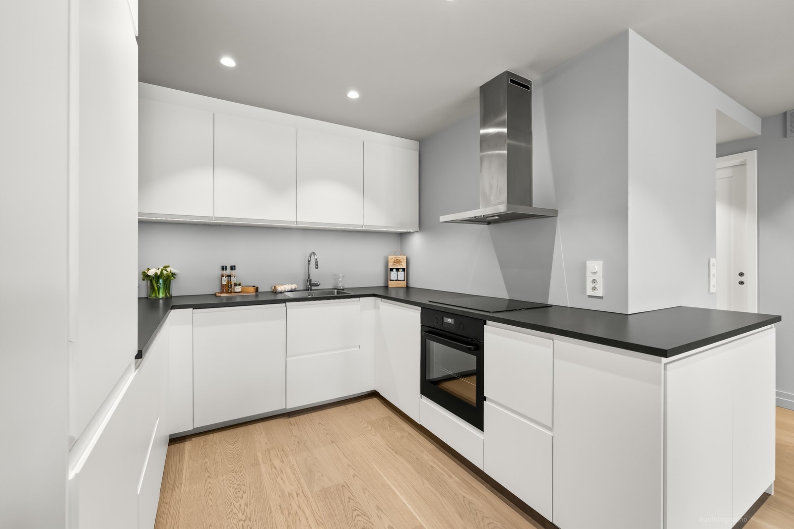 Moderne og stilren kjøkkeninnredning med godt utnyttet skap- og benkeplass. Galleribilde