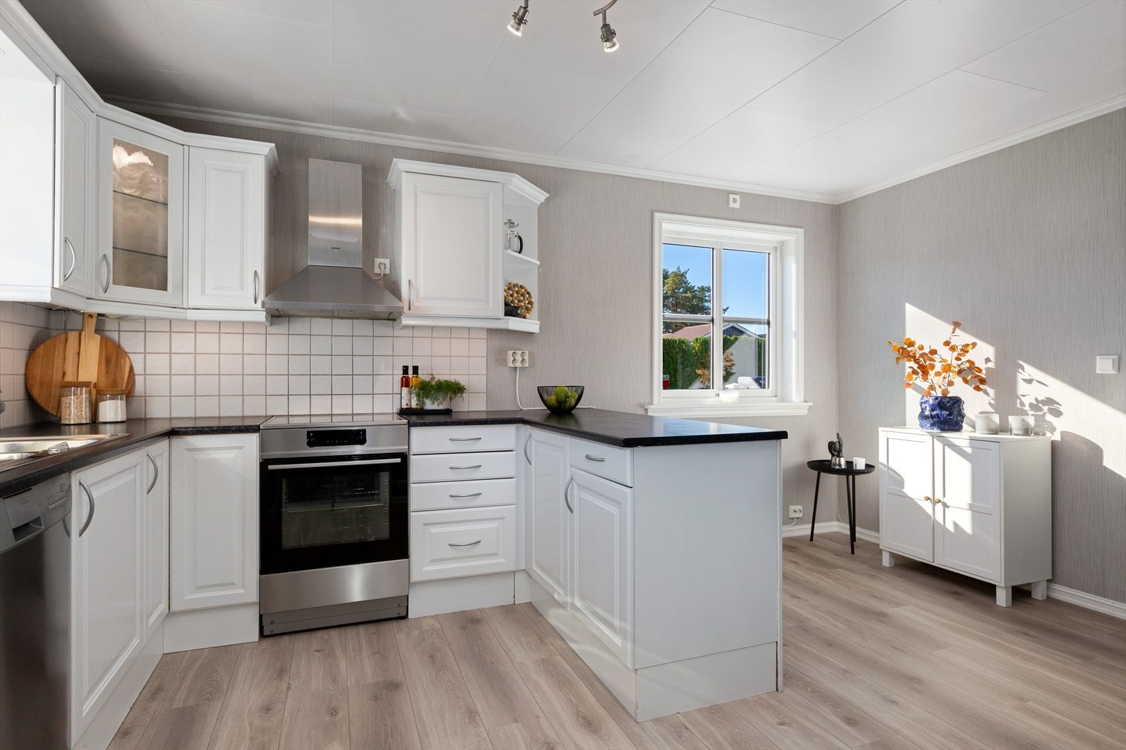 Kjøkkenet har en meget pen innredning med profilerte fronter, hvorav noen har glass. Benkeplaten er i laminat med en nedfelt, dobbel kjøkkenkum. Galleribilde