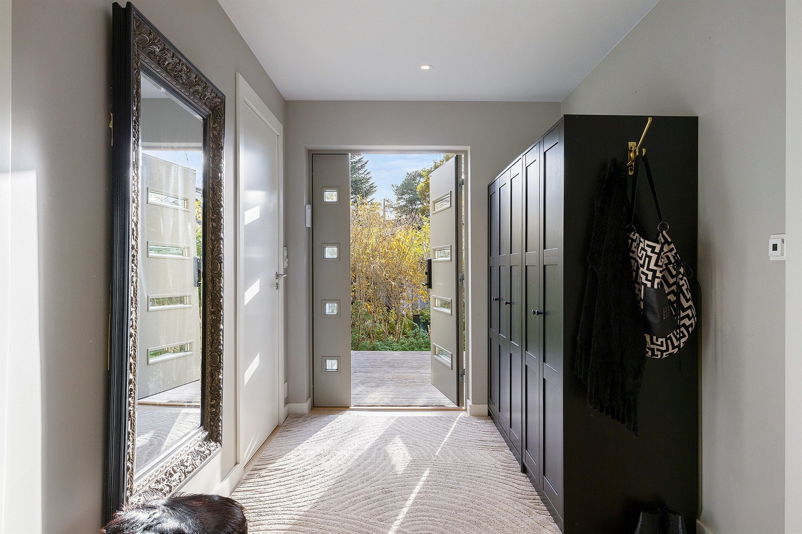 Lys og romslig entré med garderobeløsning og downlights i himlingen. Inngangsdøren har glassfelt som slipper inn naturlig lys. Galleribilde