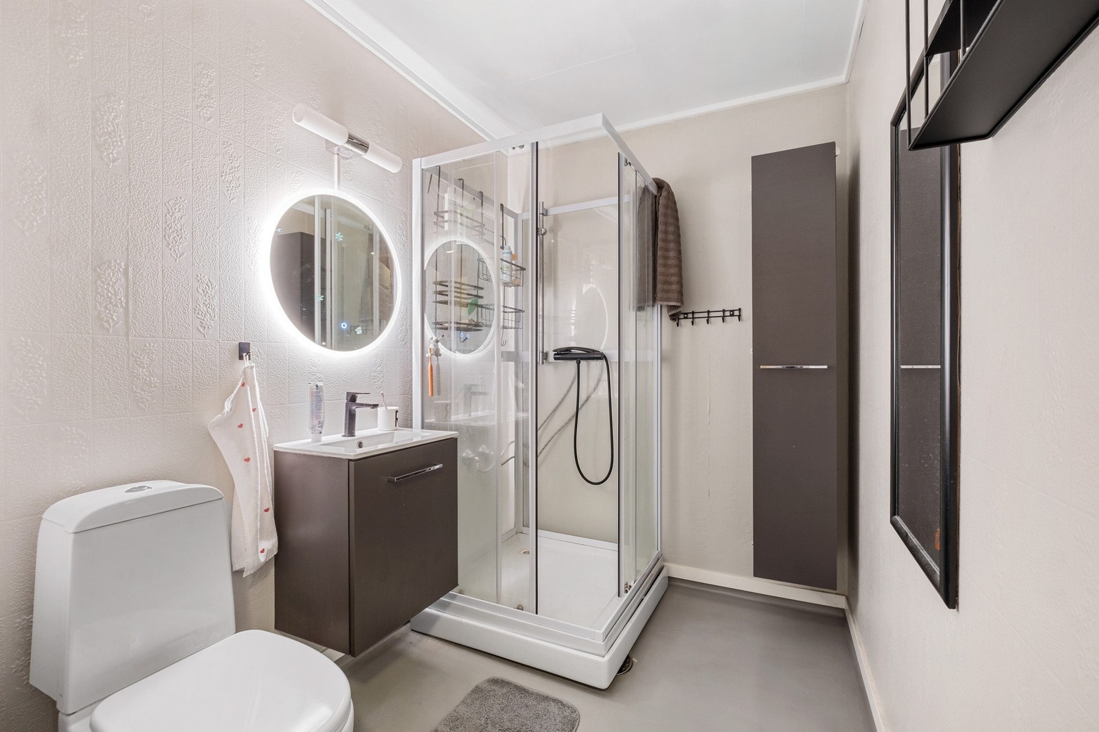 Badet er utstyrt med toalett, servant, baderomsinnredning og dusjkabinett. Galleribilde