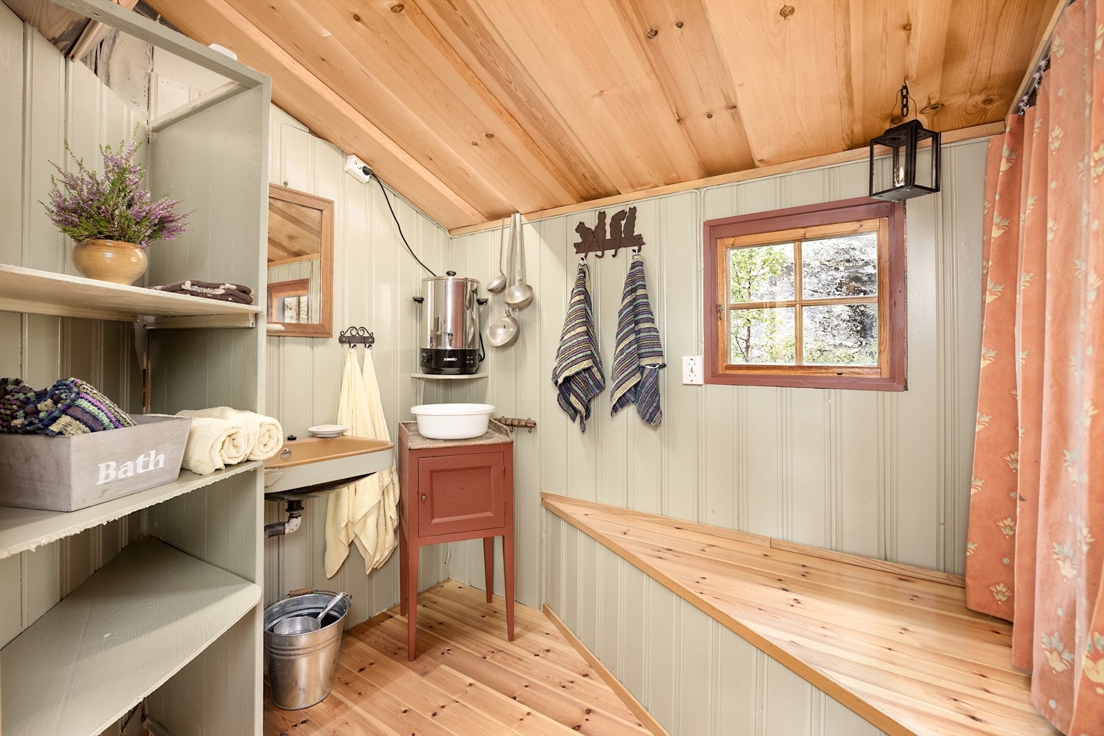 Enkelt og nostalgisk bad med løsninger som gir en touch av luksus - rennende varmt vann, utslagsvask og en gassbrenner som gir rask og god varme. Galleribilde