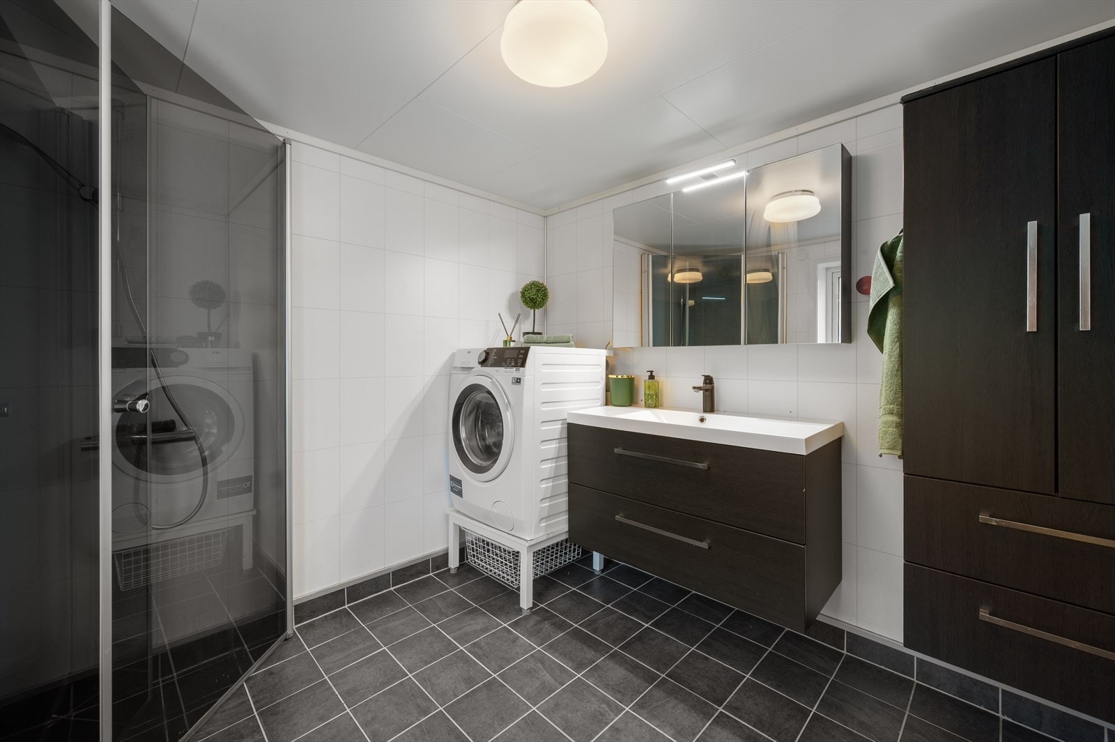 Badet har dusj med innfellbare dører i herdet glass og opplegg for vaskemaskin. Galleribilde