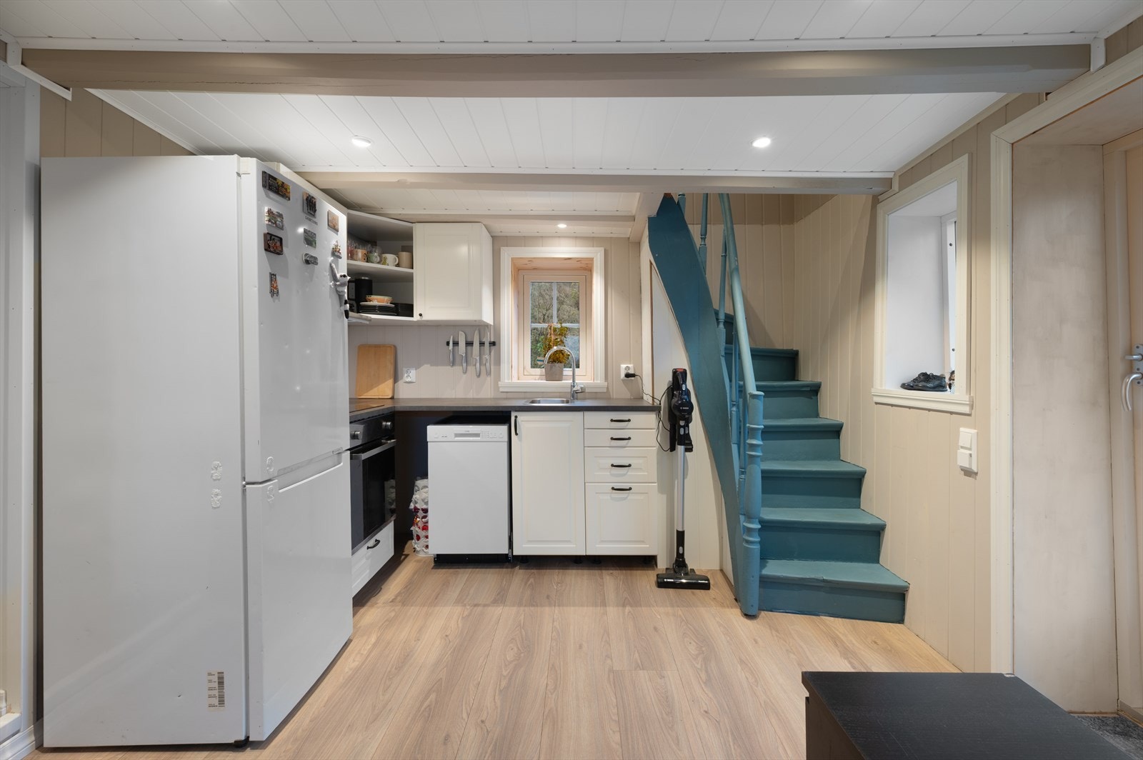 Kjøkkenet er innredet med kjøleskap, komfyr, ovn og oppvaskmaskin. Galleribilde