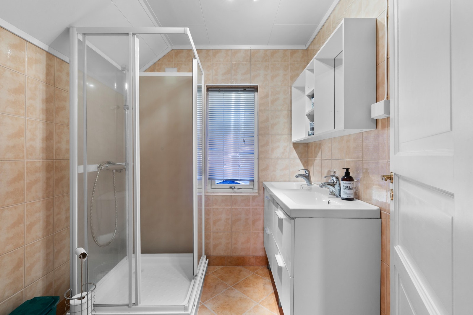 Badet har dusjkabinett, toalett og servant med belyst overspeil. Galleribilde