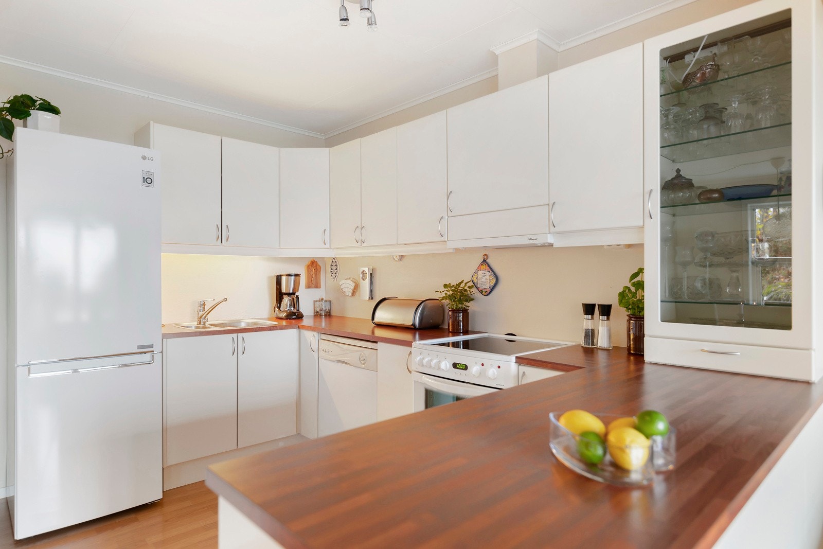 Kjøkkenet har godt med både skap- og benkeplass. Her er kjøleskap, komfyr og oppvaskmaskin som følger med i handelen. Galleribilde