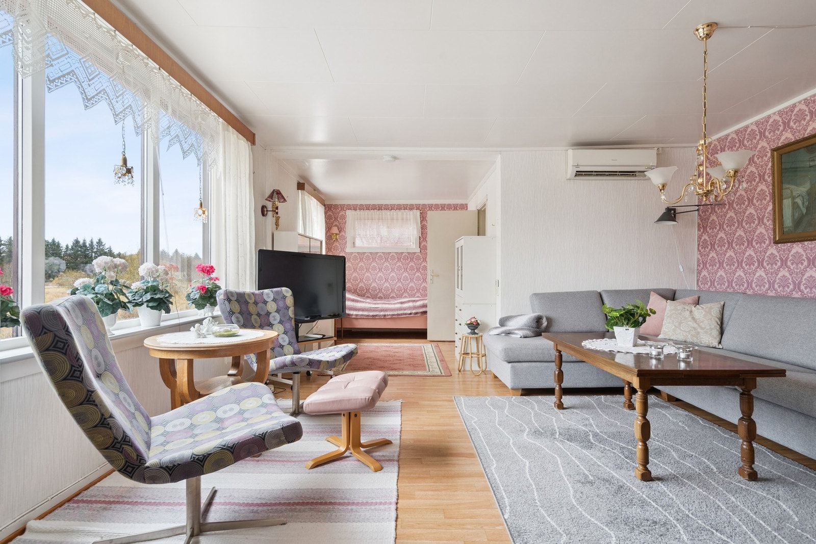 Lys og luftig stue med adkomst fra kjøkkenet. Rommet har store vindusflater, varmepumpe og fyringsovn som behøver oppgradering. Galleribilde