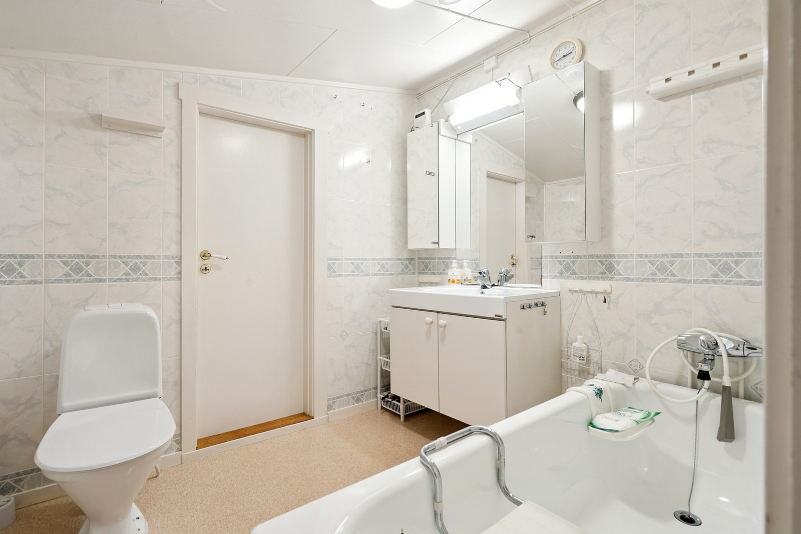 Baderom på hovedplan med badekar, romslig innredning og direkte adkomst til et praktisk vaskerom. Galleribilde