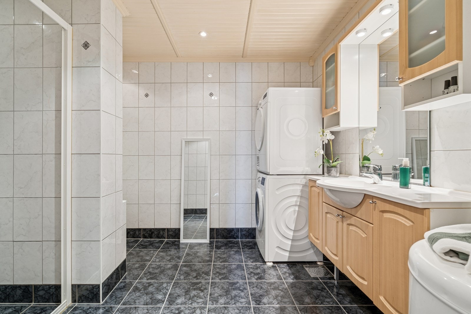 Badet er utført med mørke gulvfliser m/gulvvarme og hvite veggfliser Galleribilde