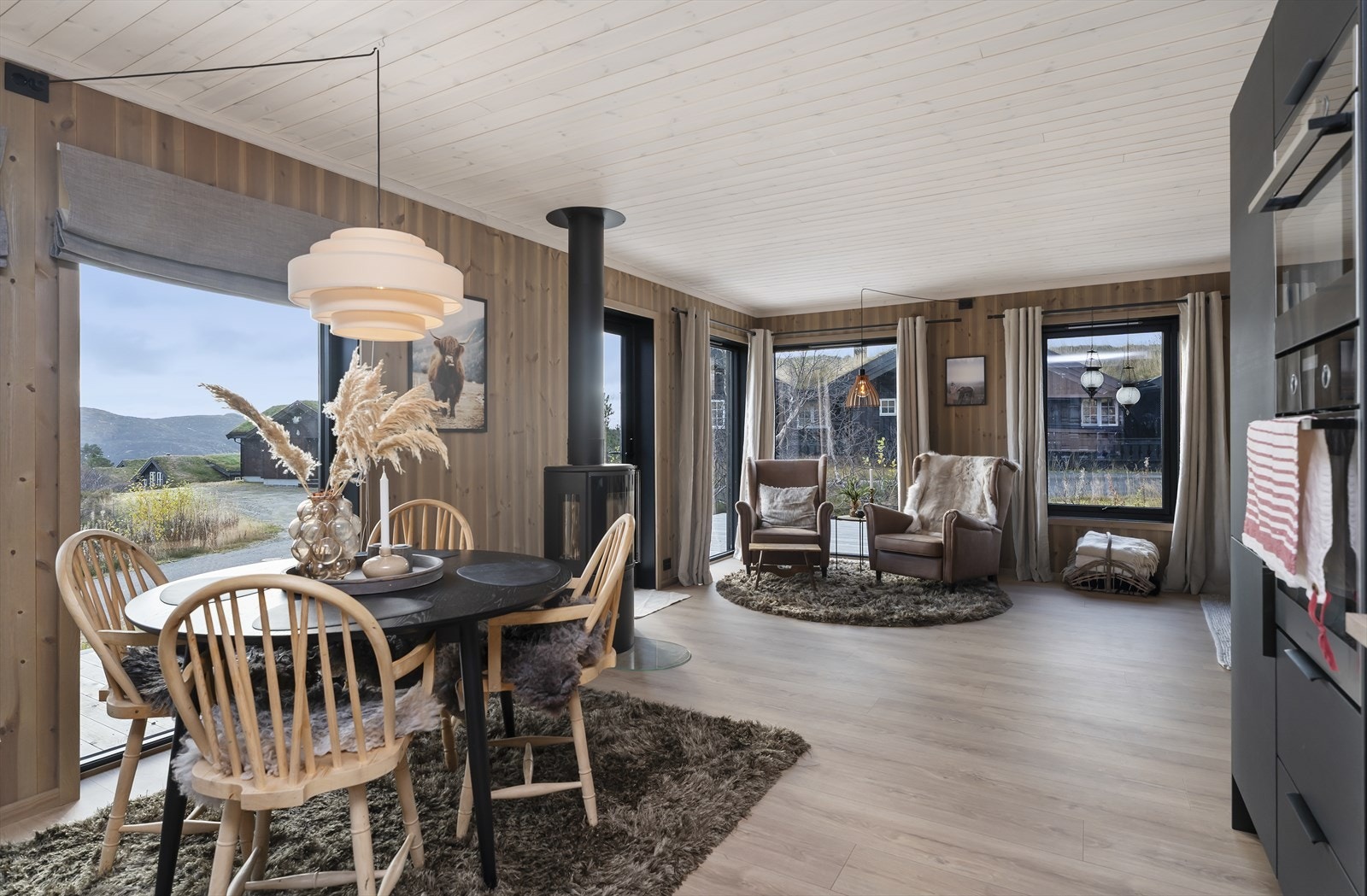 Stue og kjøkken i delvis åpen løsning med god plass til møblering i flere soner Galleribilde