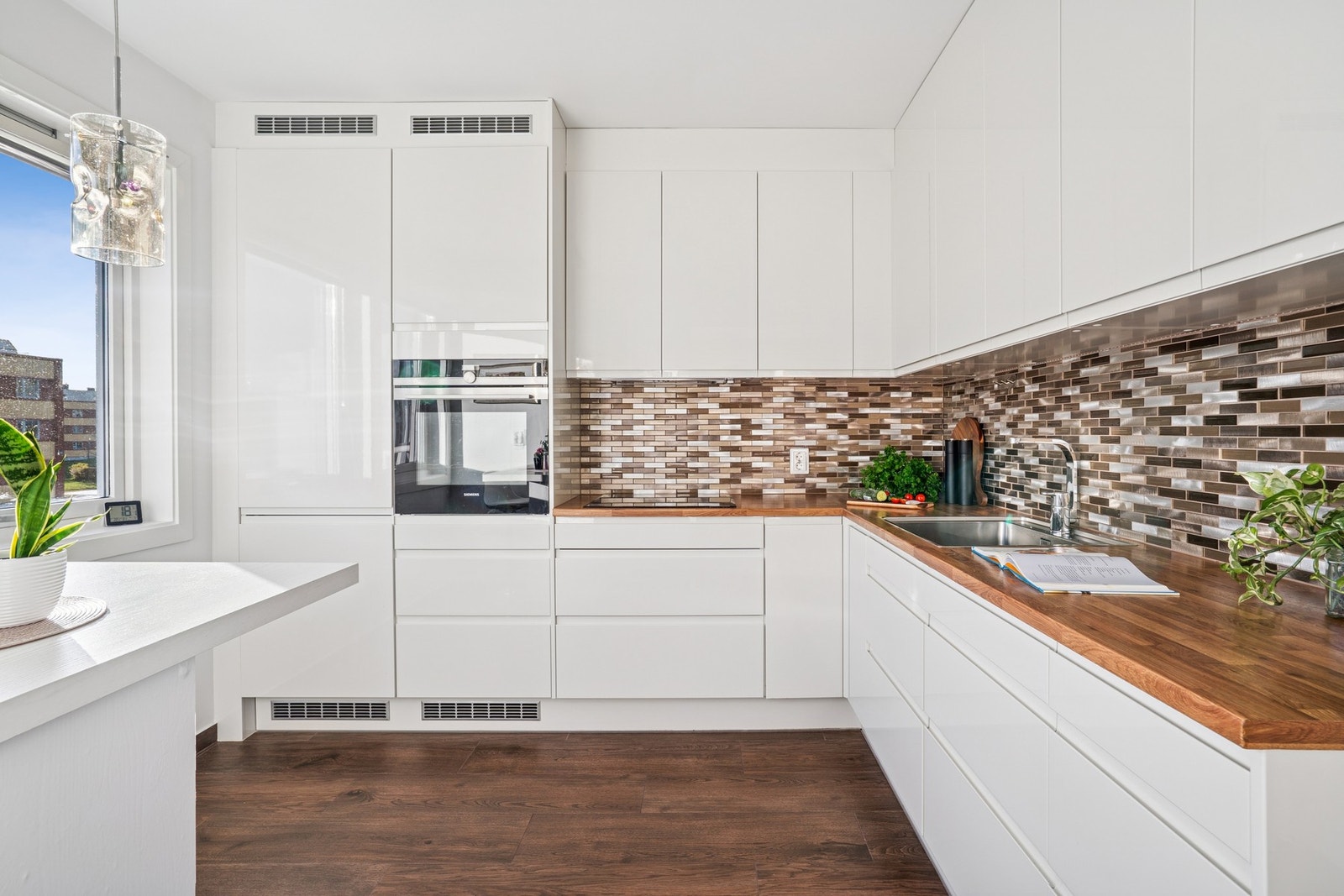 Kjøkkenet er fra 2019, med flislagt gulv av høy kvalitet, fliser i glasskeramikk og metall over benk, samt innredning fra Norema. Galleribilde