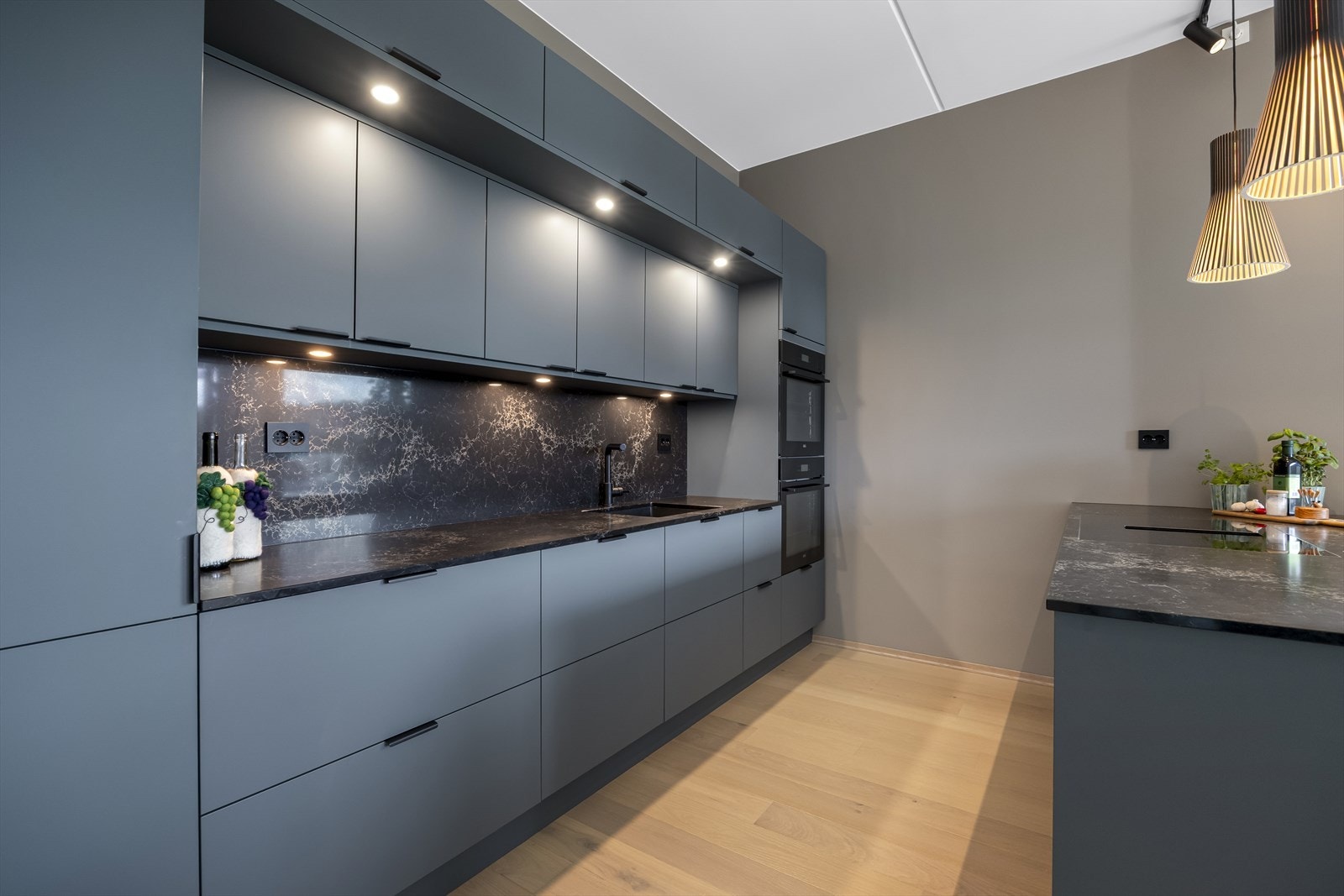 Kjøkkenet har god skap og benkeplass, med kompositt stein benkeplate og praktisk halvøy mot spisestuen. Galleribilde