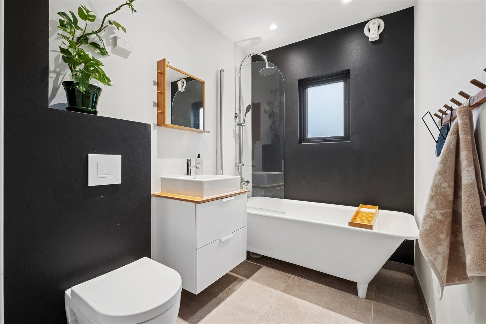 Bad i 1.etasje er pusset opp i 2017. Utstyrt med vegghengt toalett, servantinnredning og badekar. Galleribilde