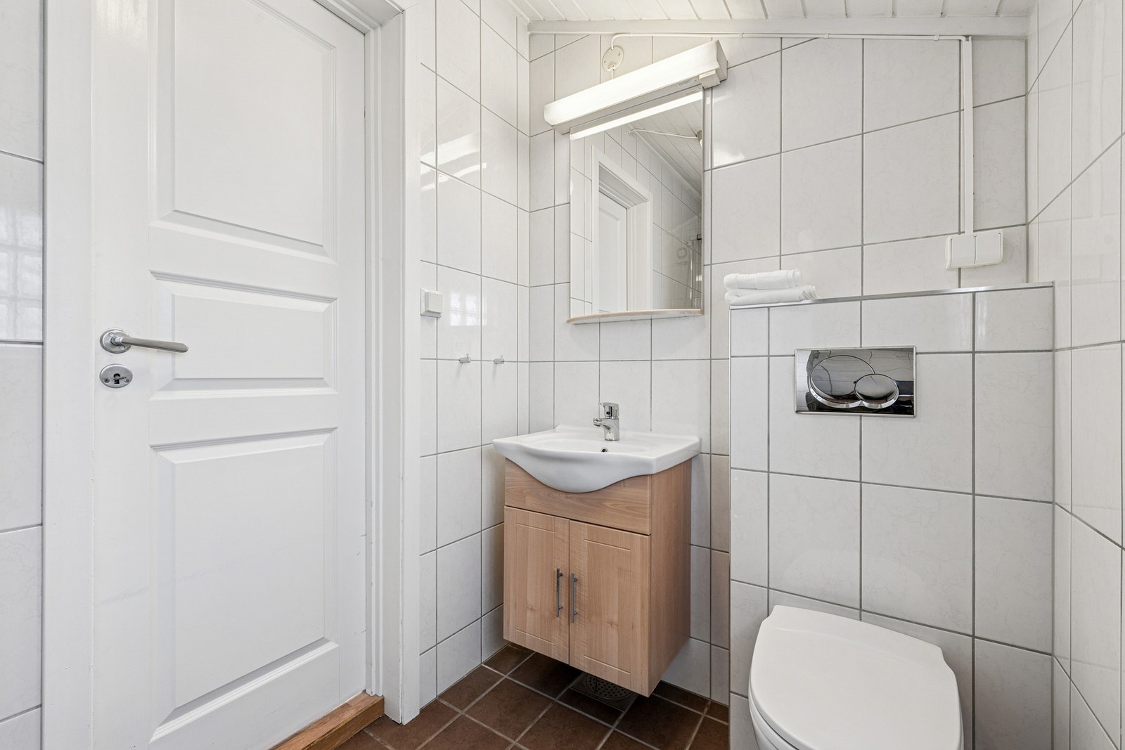 Pent flislagt bad med varme i gulv, romslig dusjnisje, vegghengt toalett og servant med oppbevaringsskap Galleribilde