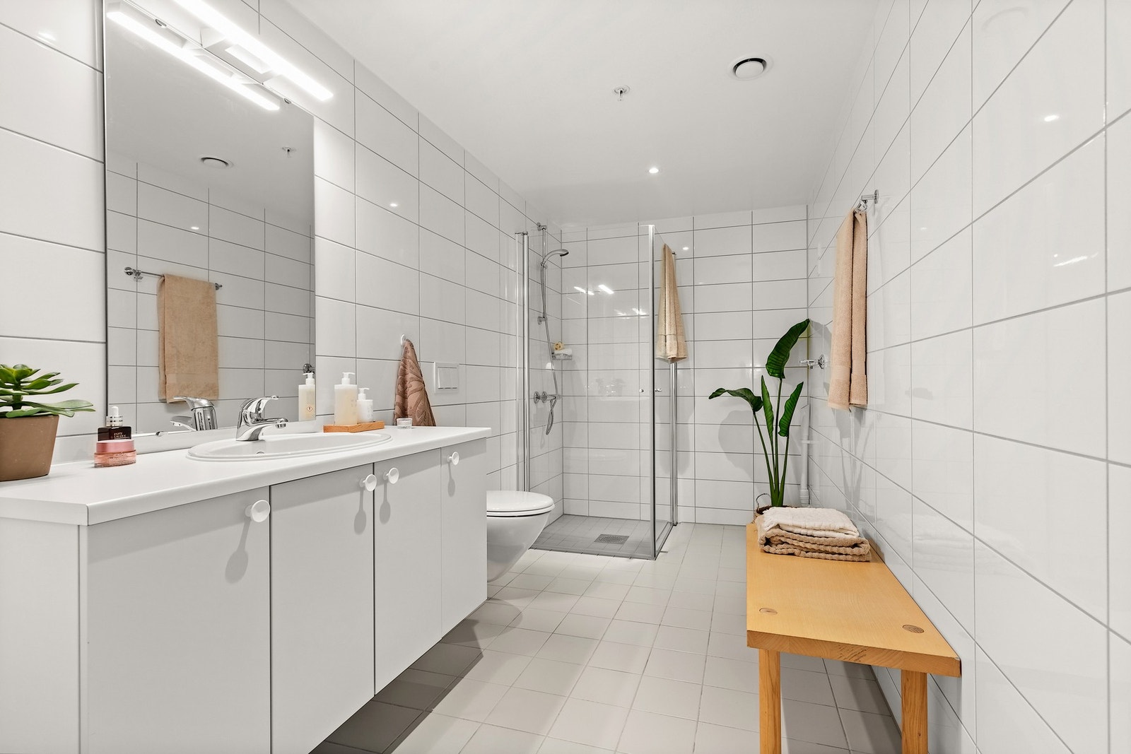 Tilknyttet entré ligger et bad fra byggeår, innredet med servant med skapseksjon, veggmontert toalett og et dusjhjørne. Galleribilde