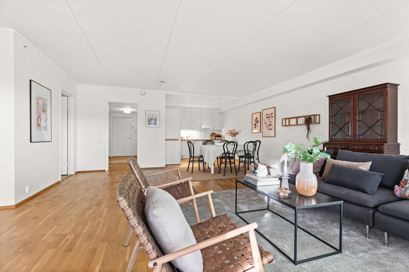 Boligens stue med spiseplass er tilknyttet et kjøkken med innredning fra byggeår. Galleribilde