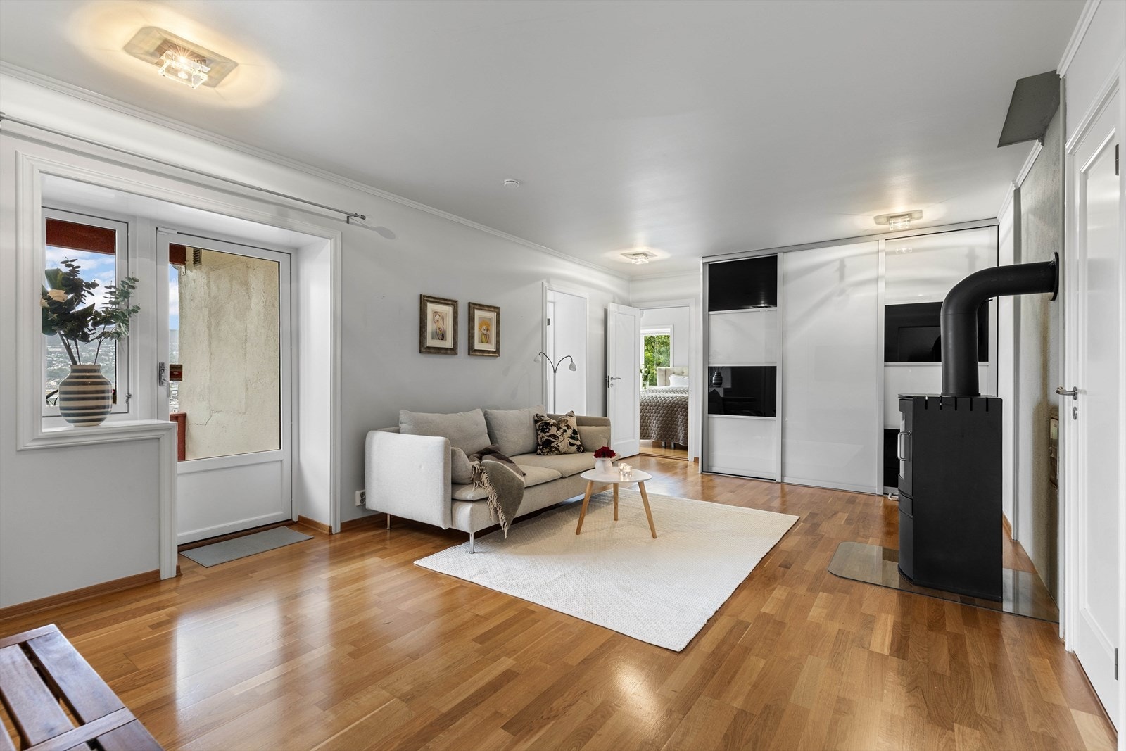 Stue med peisovn og skyvedørsgarderobe Galleribilde