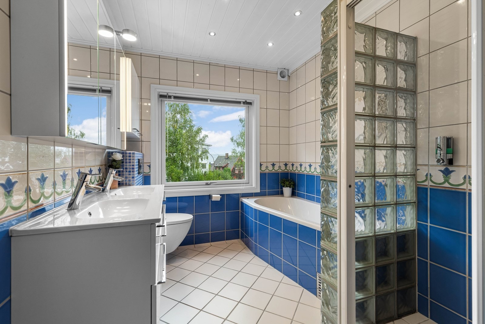 Romslig flislagt bad med badekar Galleribilde