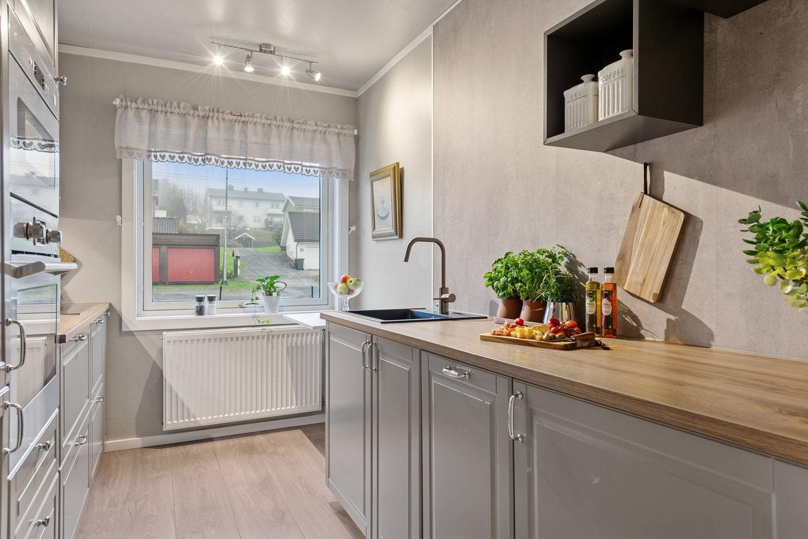 Innredning med grå profilerte fronter og benkeplate av typen laminat. Galleribilde