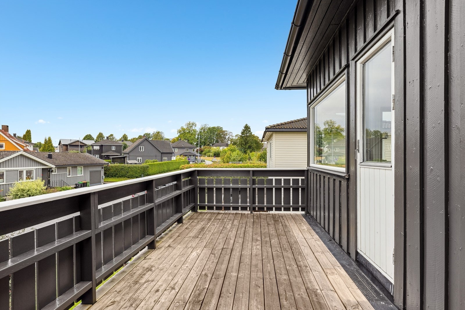 Halvpart av horisontaldelt tomannsbolig med stor solfylt balkong og fin utsikt Galleribilde