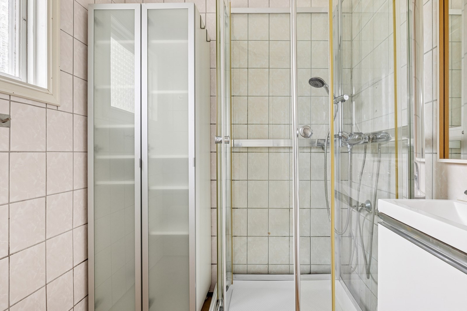 Baderom med dusjkabinett og høyskap Galleribilde